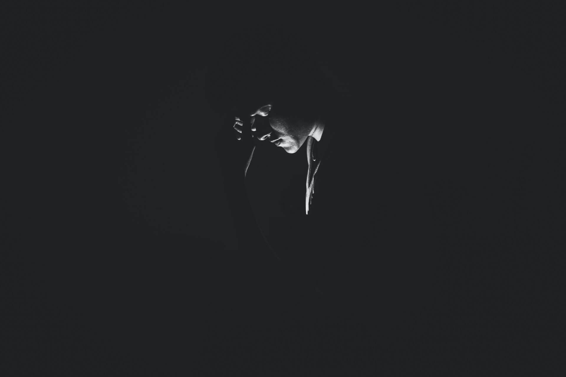 Person in dark room with dim lighting.