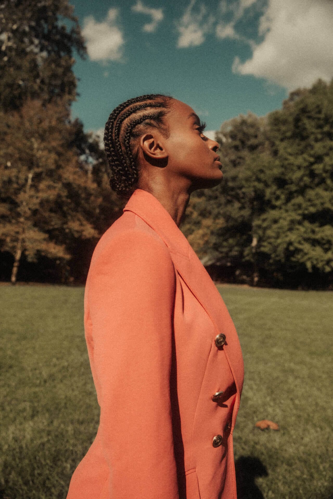 Person in orange jacket standing outdoors.