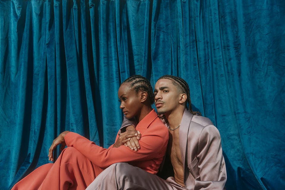 Two people in colorful suits, seated.
