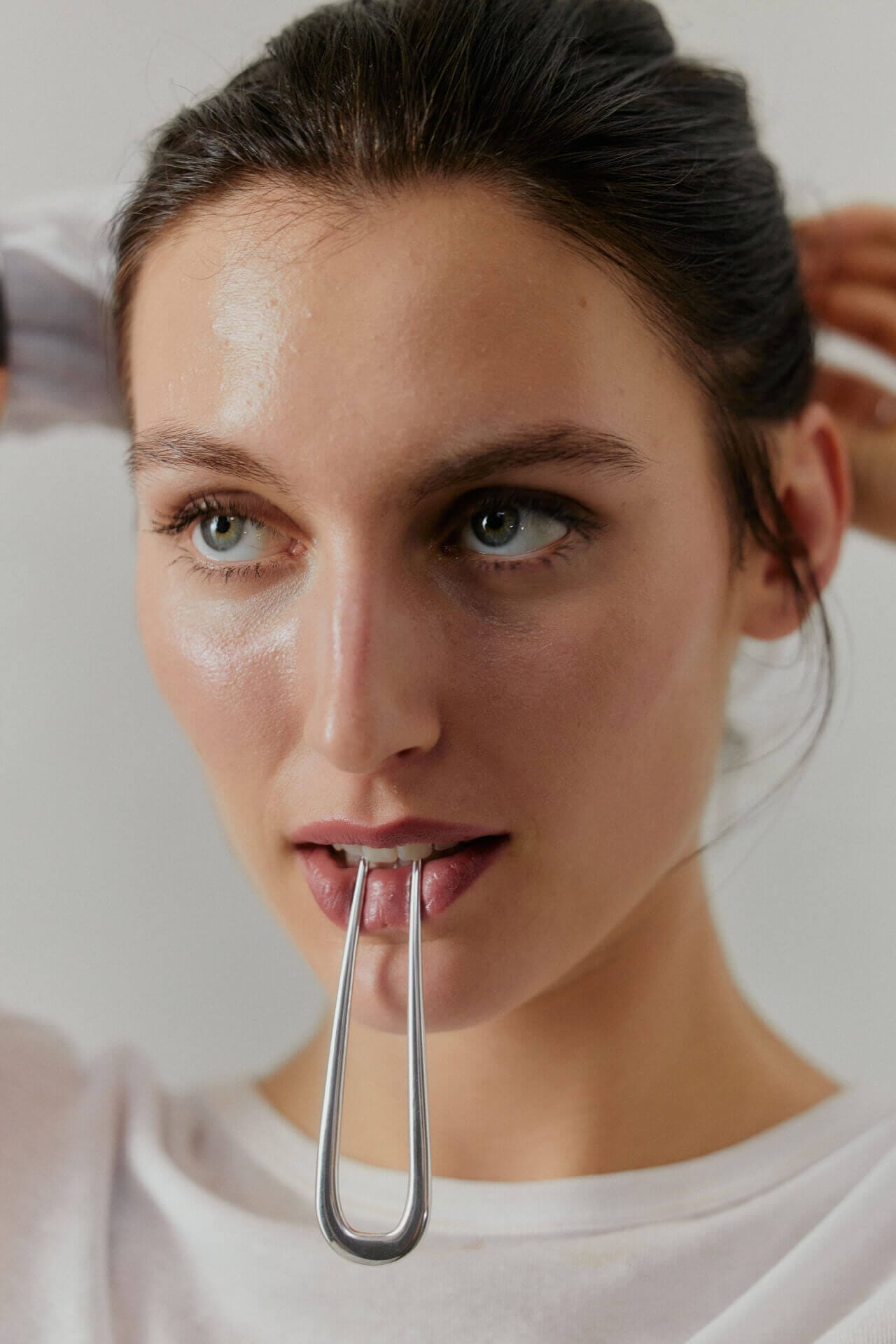 Woman using a metal facial tool.