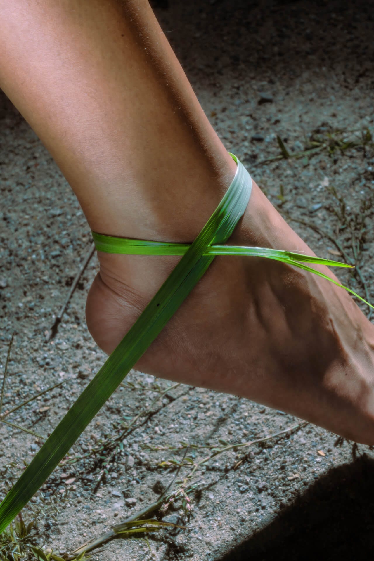 Bare foot with green grass ankle bracelet.