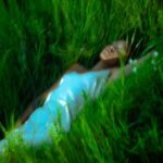 Person lying in lush green grass.