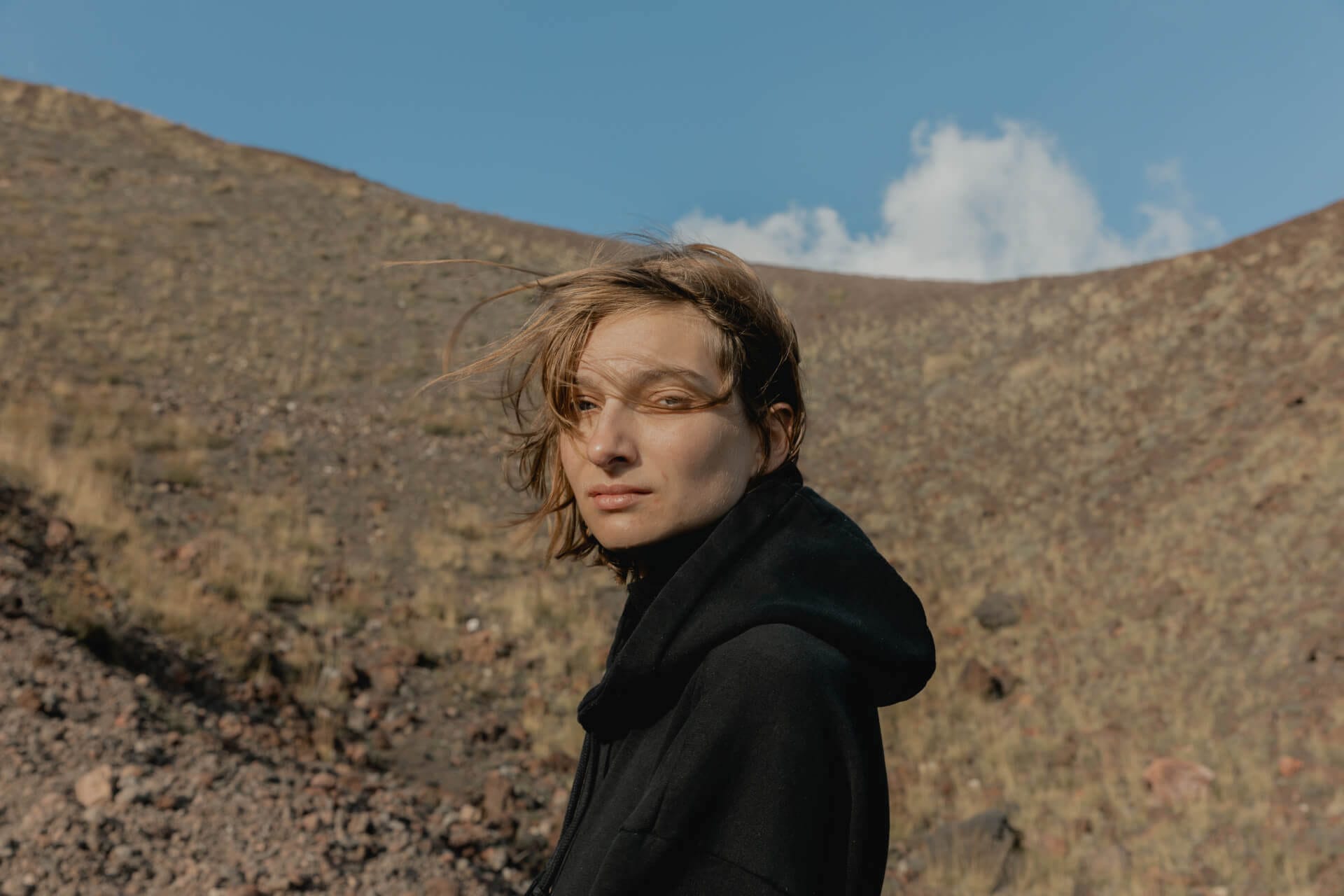 Person standing in windy desert landscape.