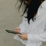 Woman looking at phone outdoors.