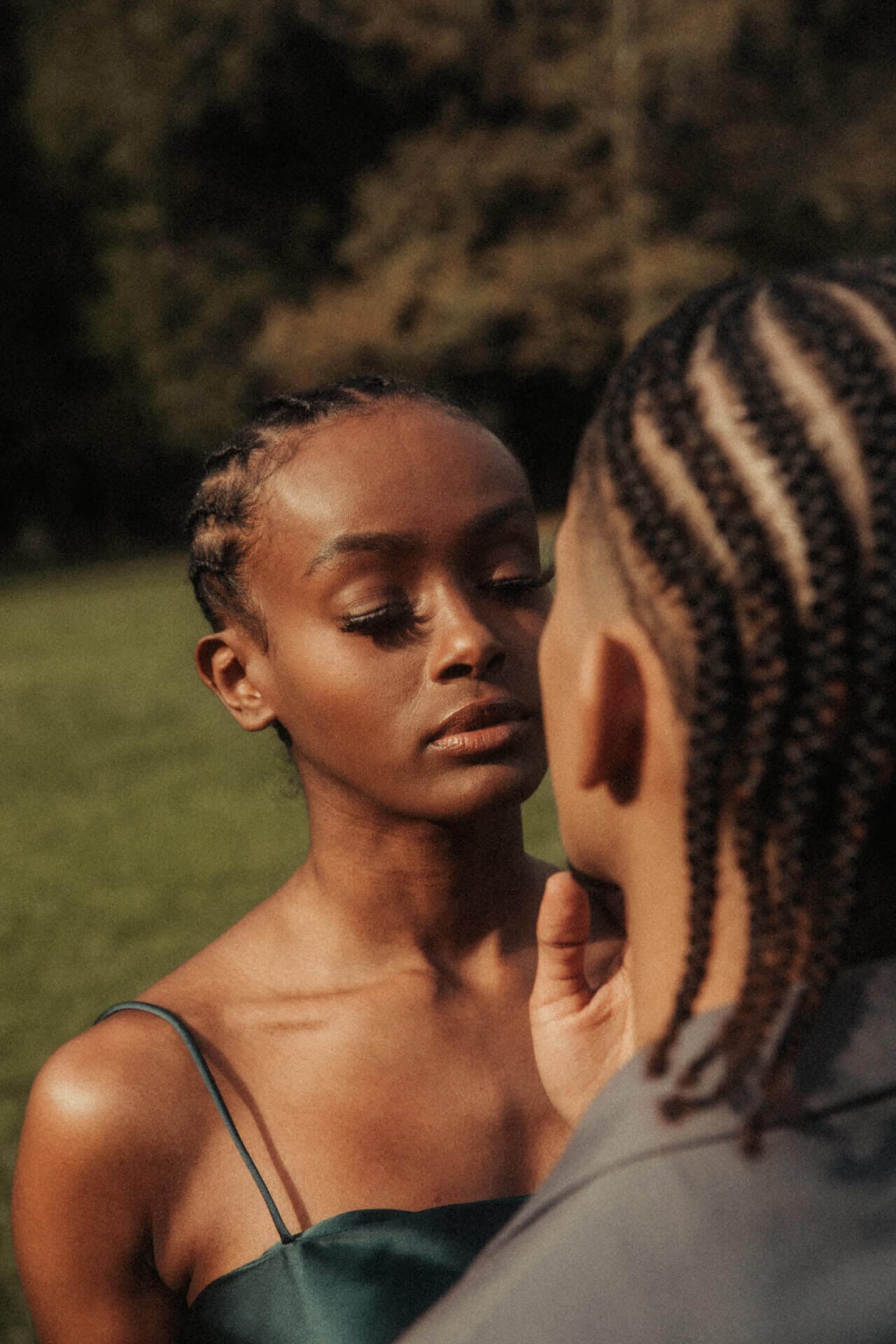 Two people facing each other outdoors.