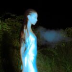 Person in blue light, exhaling mist outdoors.