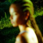 Blurred portrait of person in nature setting.