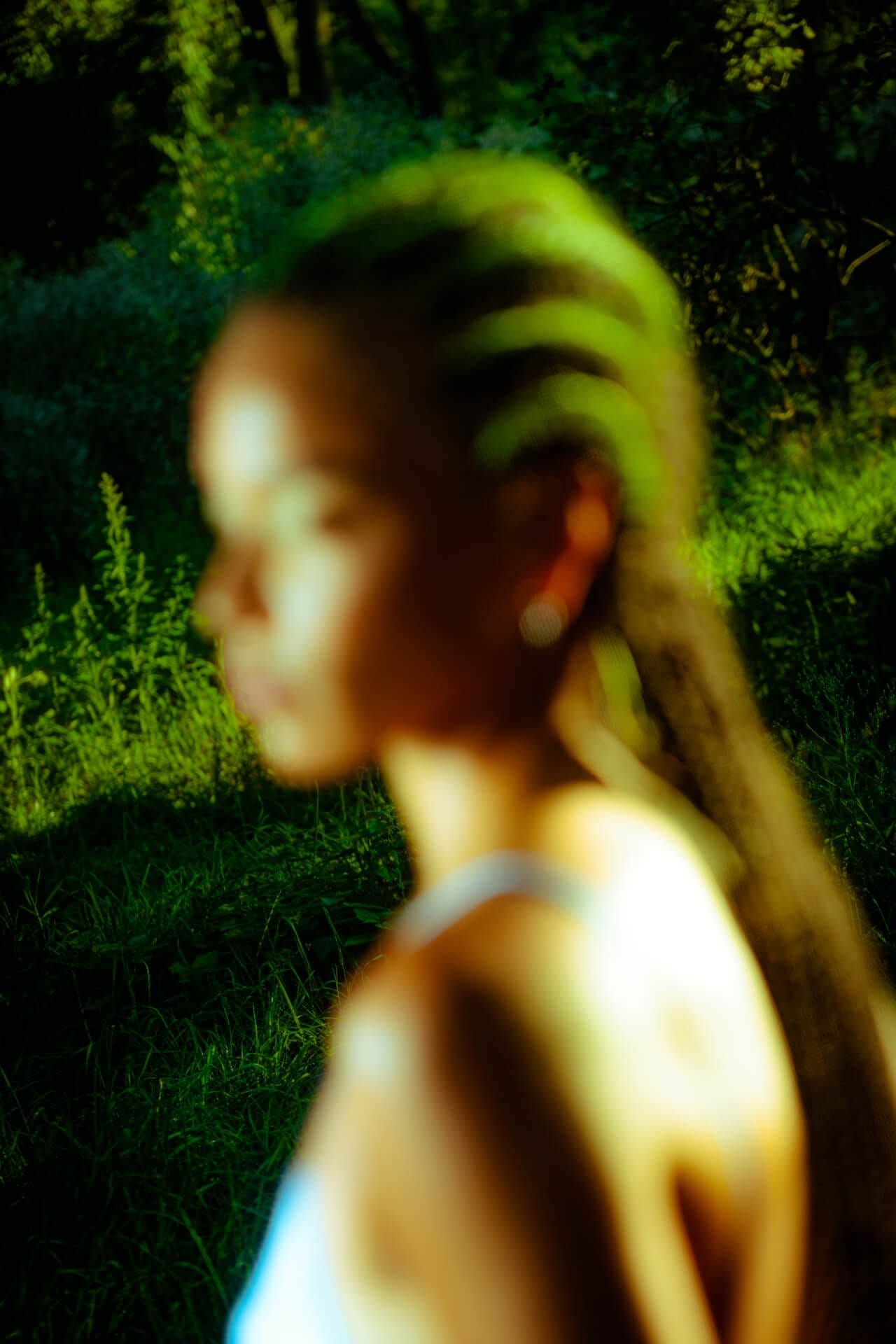 Blurred portrait of person in nature setting.