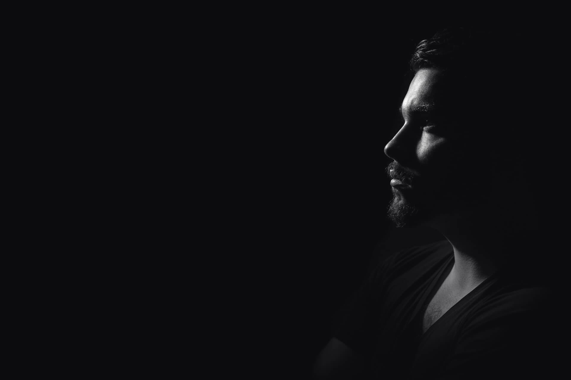Man in shadowy profile, black and white.