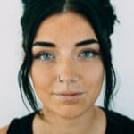 Woman with dark hair and nose ring.